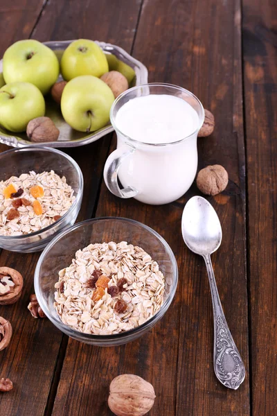 Oatmeal in bowls, yogurt, apples, dried apricots — Stock Photo, Image