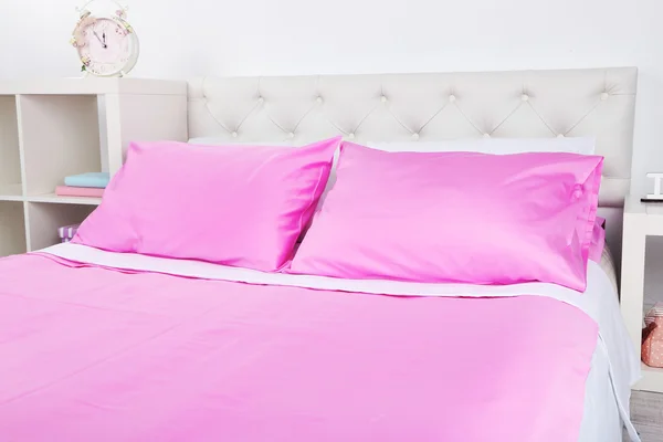 Bett in rosa Bettwäsche — Stockfoto