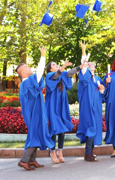 Estudantes jogando chapéus de formatura — Fotografia de Stock