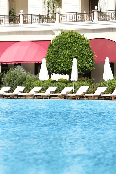Lounge sunbeds near swimming pool — Stock Photo, Image