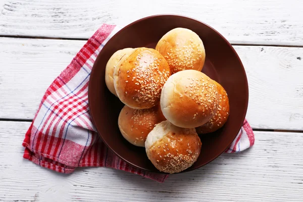 Deliciosos bollos con sésamo en plato —  Fotos de Stock