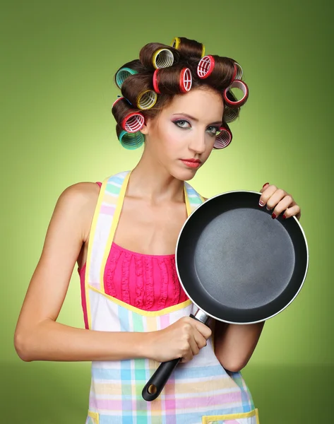 Hermosa chica en rulos de pelo sobre fondo verde — Foto de Stock