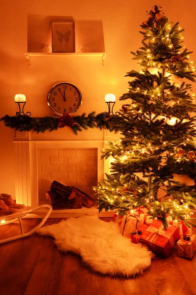 Árbol de Navidad cerca de chimenea en la habitación — Foto de Stock