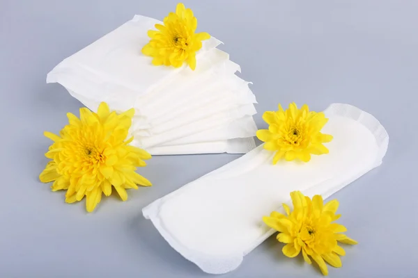 Sanitary pads and yellow flowers — Stock Photo, Image