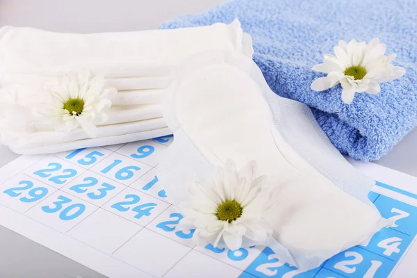 Sanitary pads, calendar, towel and white flowers