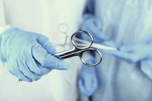 Surgeon's hands holding different instruments — Stock Photo, Image