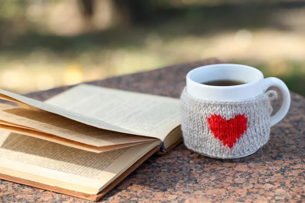Cup with hot drink and book — Stock Photo, Image