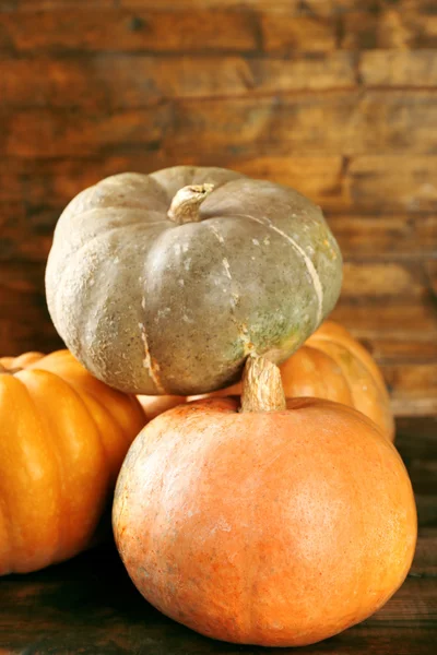 Ripe different pumpkins on wooden background — Stock Photo, Image