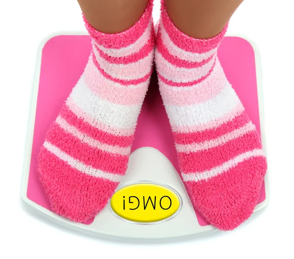 Feet in pink socks on scales — Stock Photo, Image