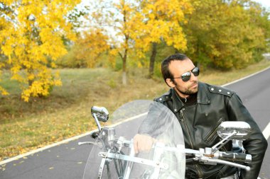 Motorcu adam bisiklet üzerinde oturur
