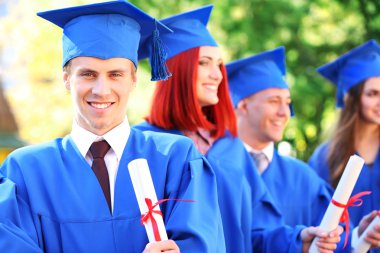 Yüksek lisans öğrencileri mezuniyet şapka ve elbise, açık havada giyiyor