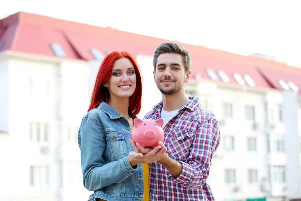 Casal amoroso com banco porquinho — Fotografia de Stock