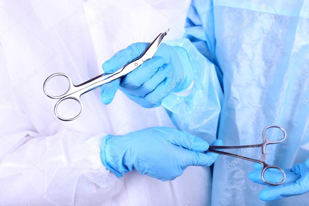 Surgeon's hands holding different instruments