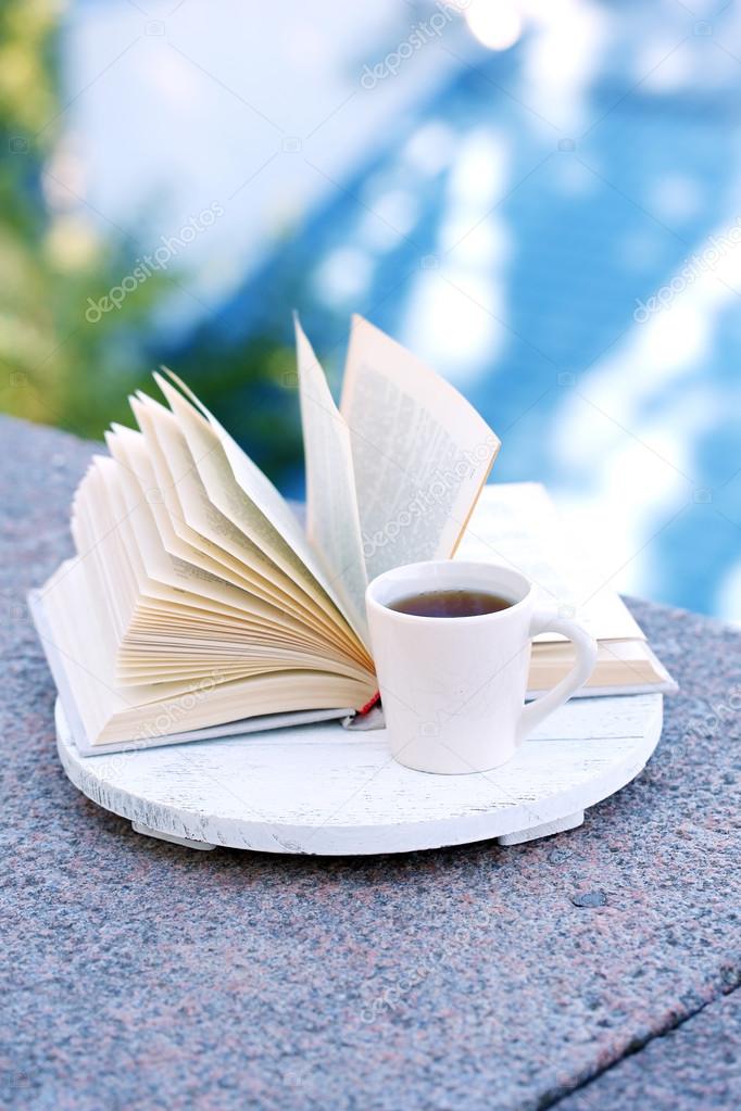 Cup with hot drink and book