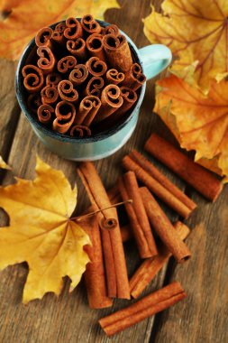 Tarçın bardağa sarı yaprakları ile sopa.