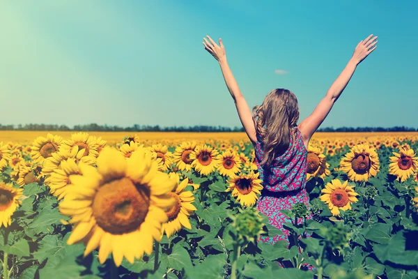 Jonge vrouw in zonnebloem veld — Stockfoto