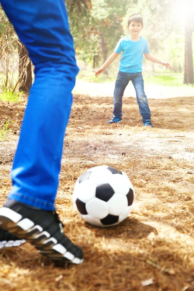 Папа и сын играют в футбол в парке — стоковое фото
