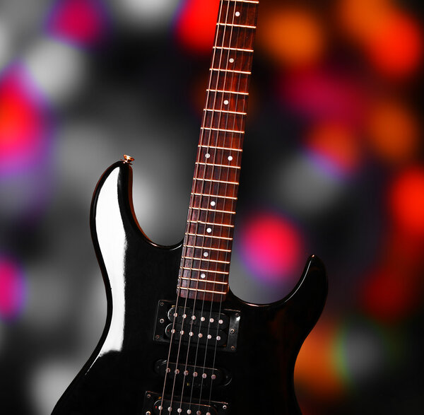 Black electro guitar on bright background
