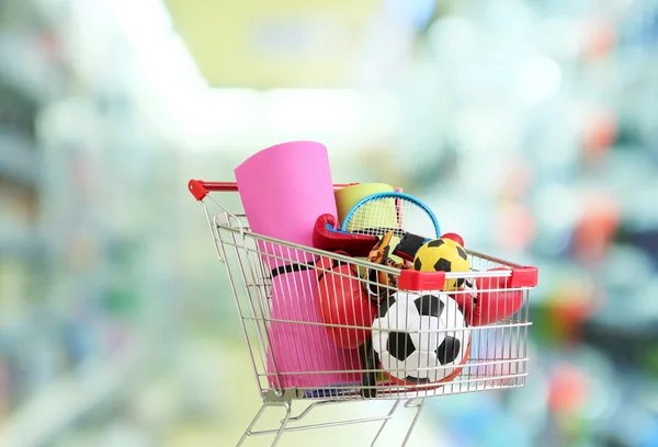 Shopping concept. Shopping cart with sport equipment on shop background — Stock Photo, Image