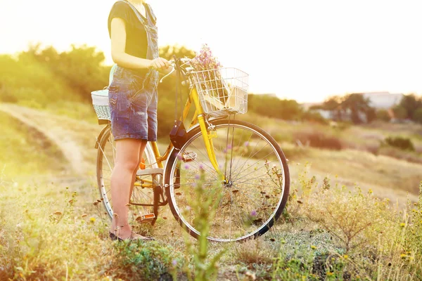 Junge Frau mit Fahrrad auf Wiese — Stockfoto