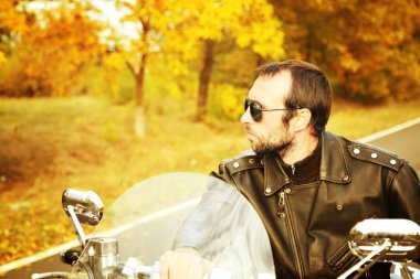 Motorcu adam bisiklet üzerinde oturur