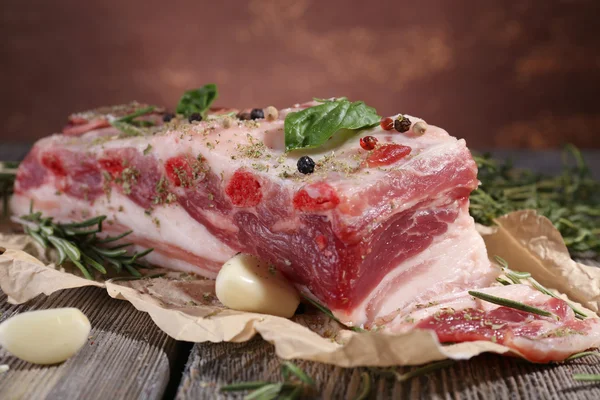 Pancetta cruda con spezie sul tavolo di legno — Foto Stock