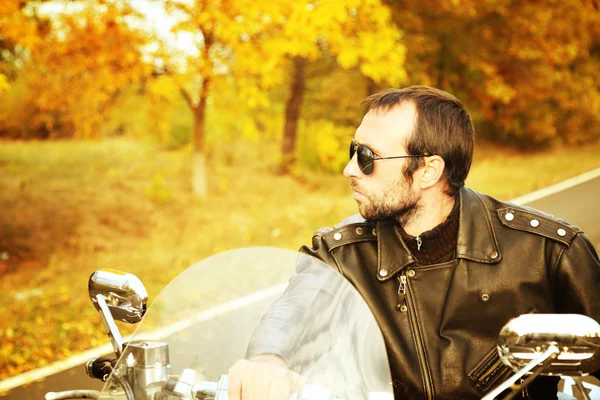 Motociclista homem senta-se na bicicleta — Fotografia de Stock