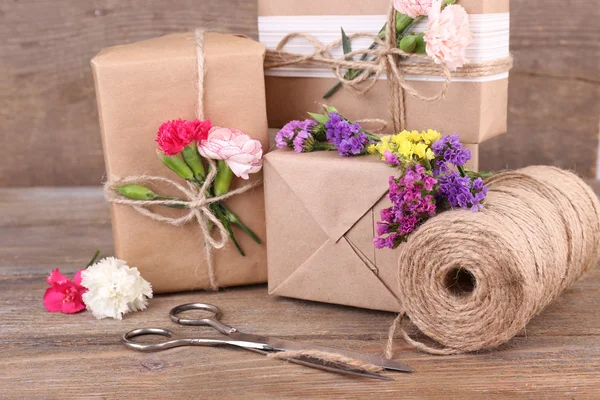 Geschenke mit Blumen und dekorativem Seil — Stockfoto