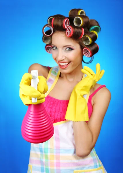 Hermosa chica en rulos de pelo sobre fondo azul — Foto de Stock