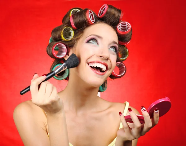 A szép lány a hajcsavarók, piros háttér — Stock Fotó