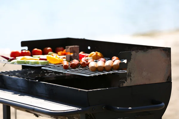 Sausages and vegetables on barbecue grill, close-up — Stock Photo, Image