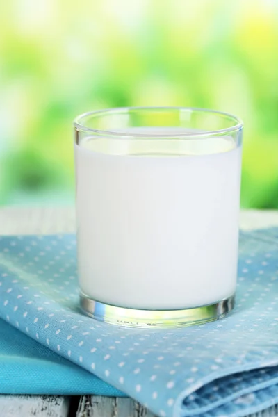 Leche en vaso sobre servilleta sobre fondo natural —  Fotos de Stock