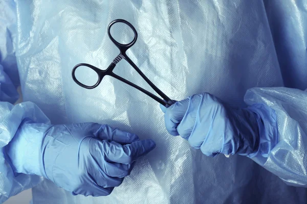 Mãos de cirurgião segurando instrumento médico — Fotografia de Stock