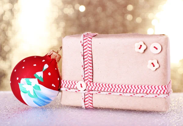 Cajas de regalo y juguete árbol de Navidad en la mesa sobre fondo brillante — Foto de Stock