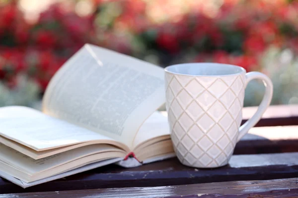 Cup with hot drink and book — Stock Photo, Image