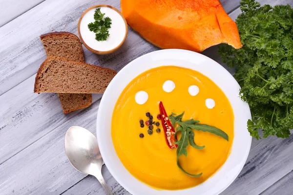 Soupe de citrouille dans une assiette et tranche de citrouille — Photo