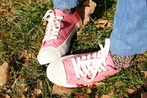 Füße in Turnschuhen auf Gras — Stockfoto