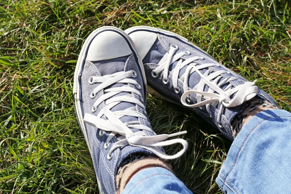 Pies en zapatillas de deporte sobre hierba —  Fotos de Stock