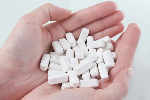 Pílulas brancas nas mãos — Fotografia de Stock