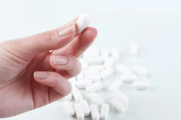 Pastillas blancas en la mano — Foto de Stock