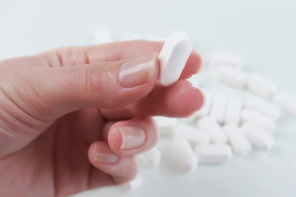 Pastillas blancas en la mano — Foto de Stock