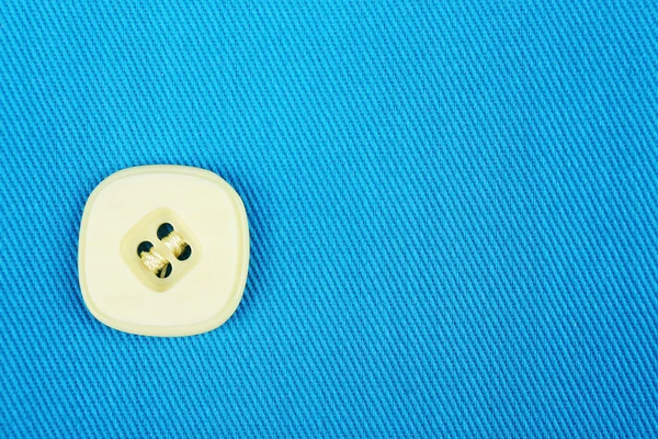 Button on blue cloth — Stock Photo, Image