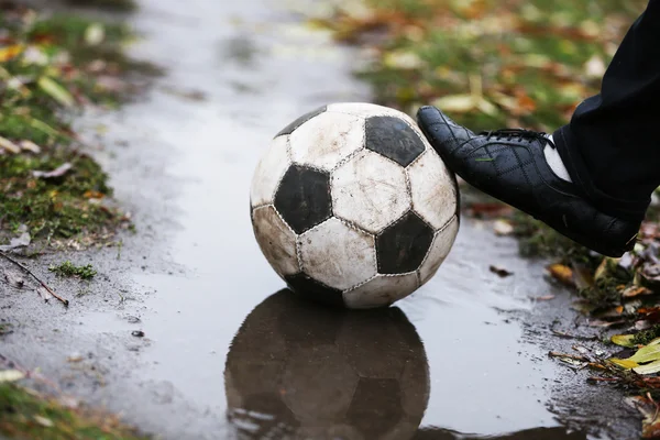 Soccer ball on ground in rainy day — Stock Photo, Image