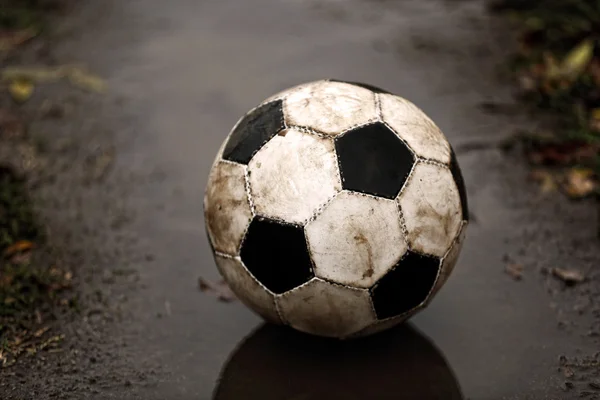 Soccer ball on ground in rainy day — Stock Photo, Image
