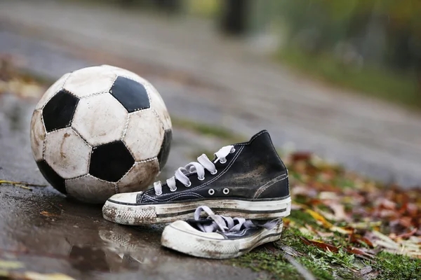 Soccer ball on ground in rainy day — Stock Photo, Image