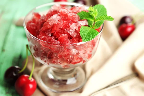 Closeup of cherry granita in glass bowl, on color wooden background — Stock Photo, Image