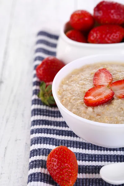 Tasty oatmeal with strawberry on table close-up — Stock Photo, Image