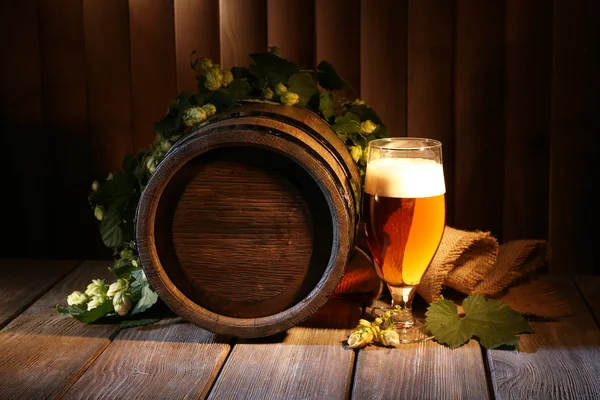 Barril de cerveja com copo de cerveja na mesa em fundo de madeira — Fotografia de Stock