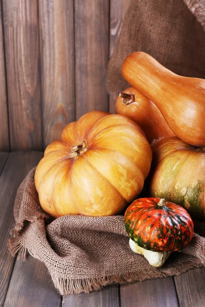 Calabazas sobre saco sobre mesa de madera — Foto de Stock