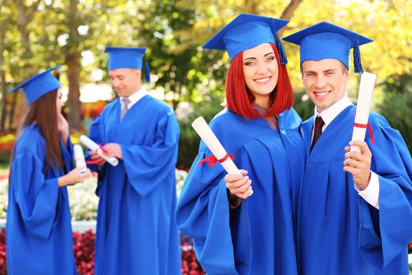 Estudantes vestindo chapéu e vestido de formatura — Fotografia de Stock